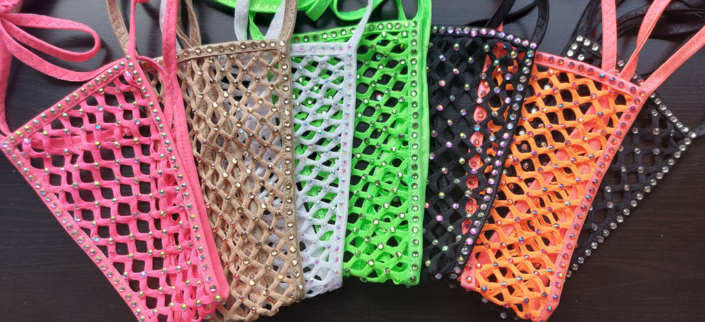 Six triangular fishnet bottoms with rhinestone trim in pink, tan, white, green, black, and orange, arranged side-by-side on a dark surface.