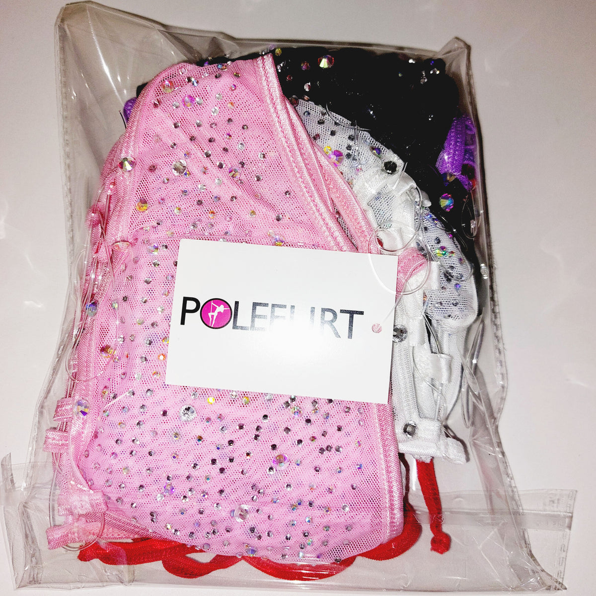 Product shot showing folded clothing items in a bag with a brand hang tag saying POLEFLIRT.