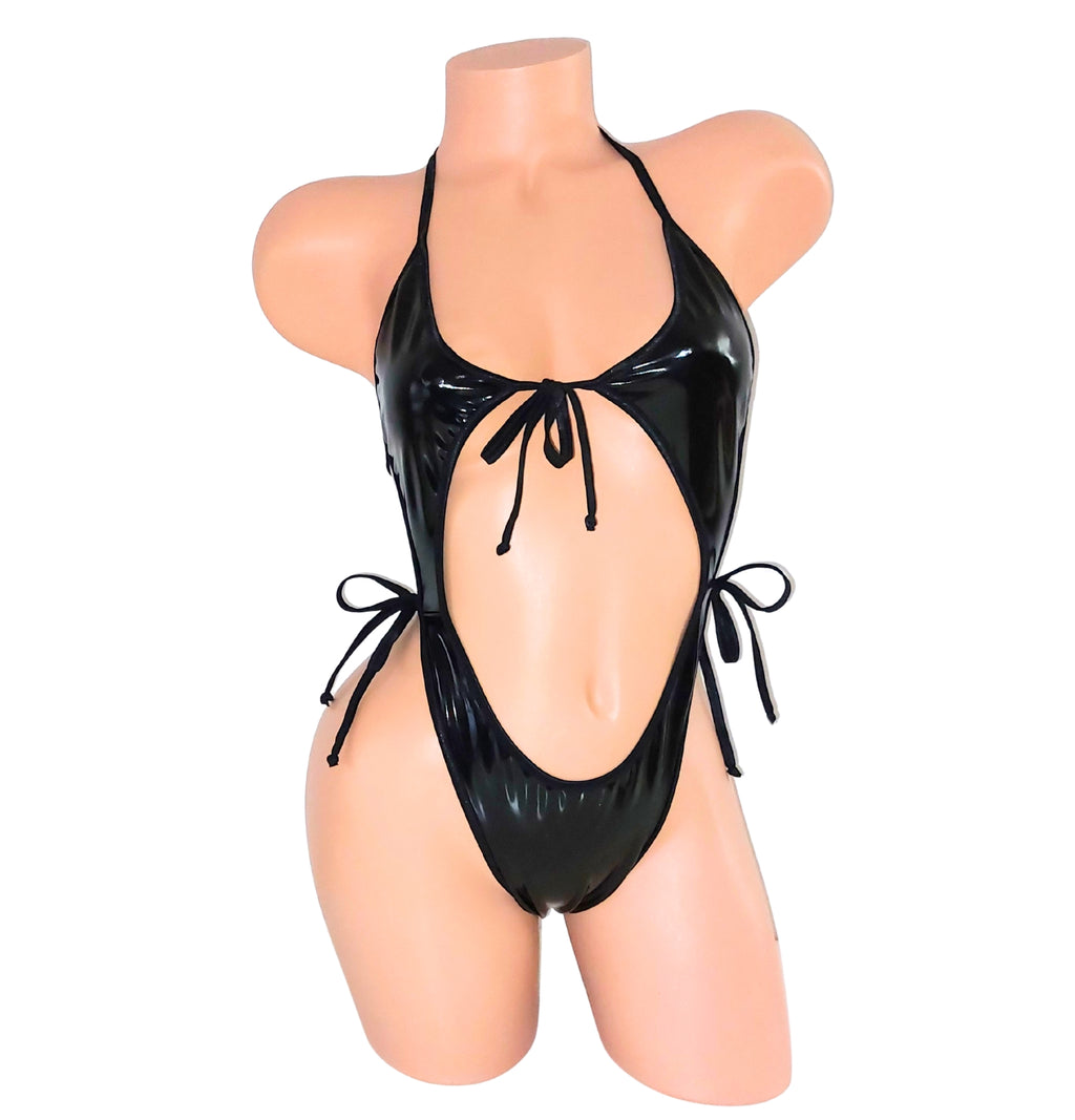 A black Vinyl wet look vinyl one piece backless leotard bodysuit on a plastic beige mannequin torso against a plain background.