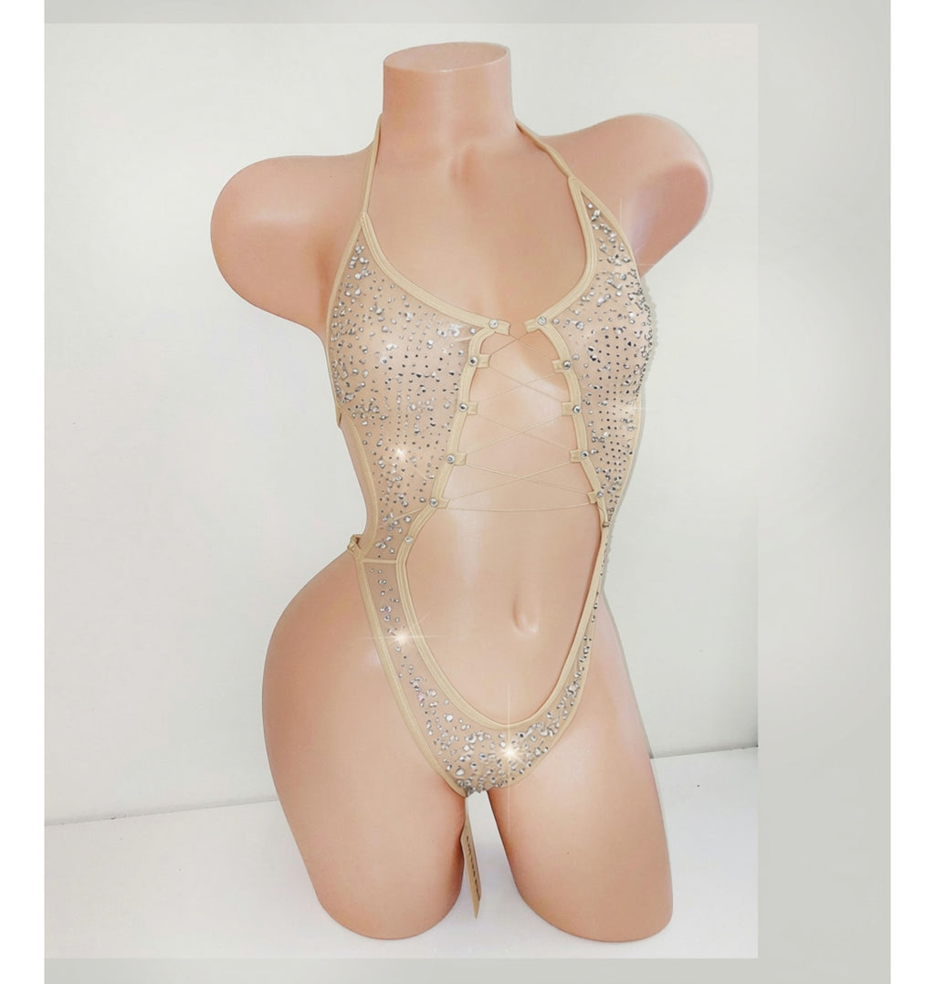 A beige mannequin displaying a beige sparkly leotard bodysuit with a center cutout and covered in rhinestones.