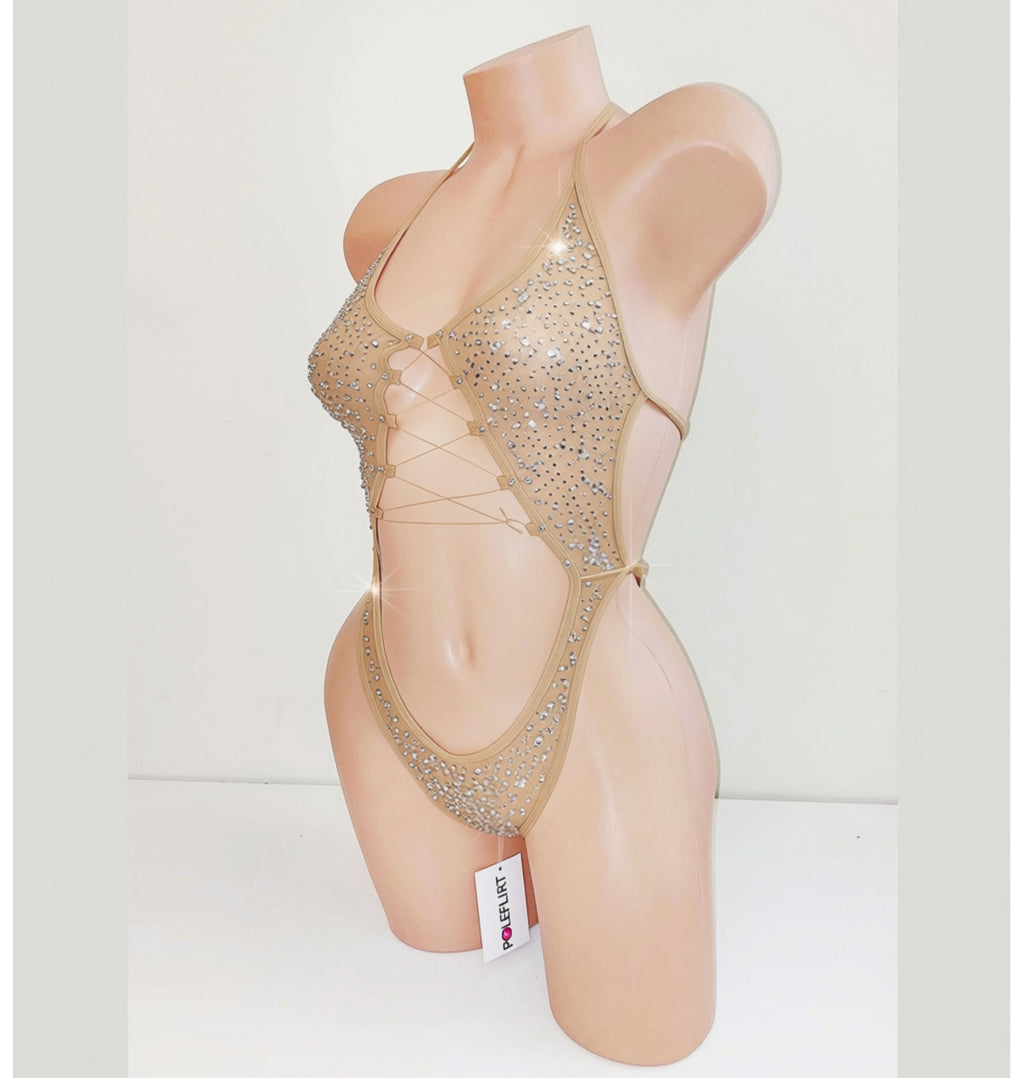 A beige mannequin displaying a beige sparkly leotard bodysuit with a center cutout and covered in rhinestones.