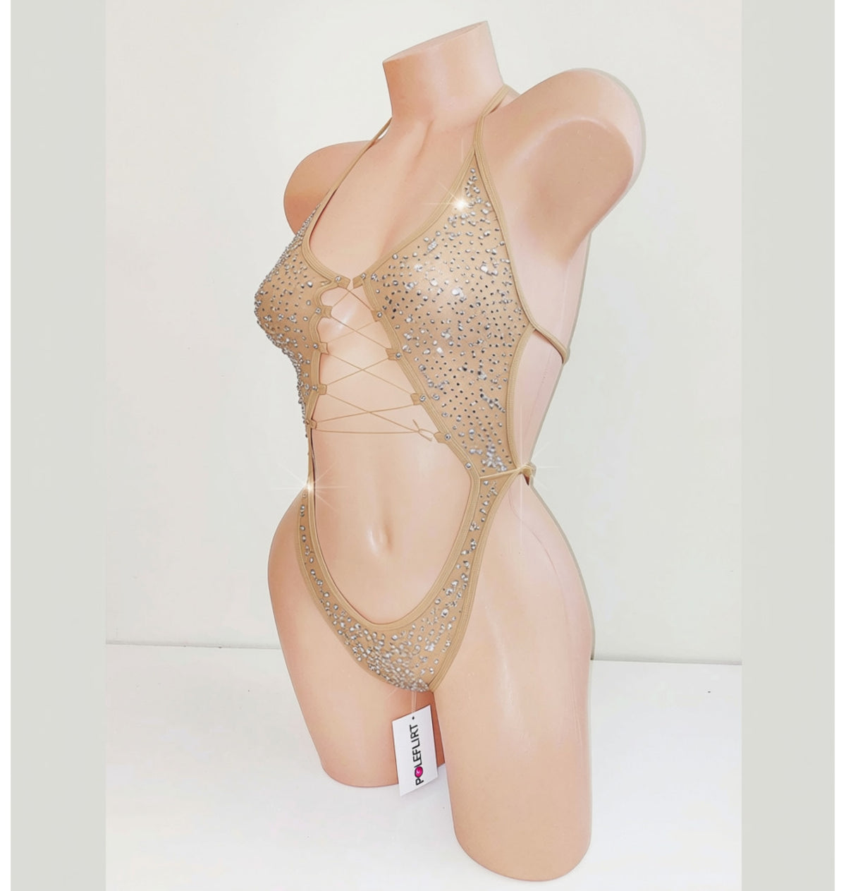 A beige mannequin displaying a beige sparkly leotard bodysuit with a center cutout and covered in rhinestones.