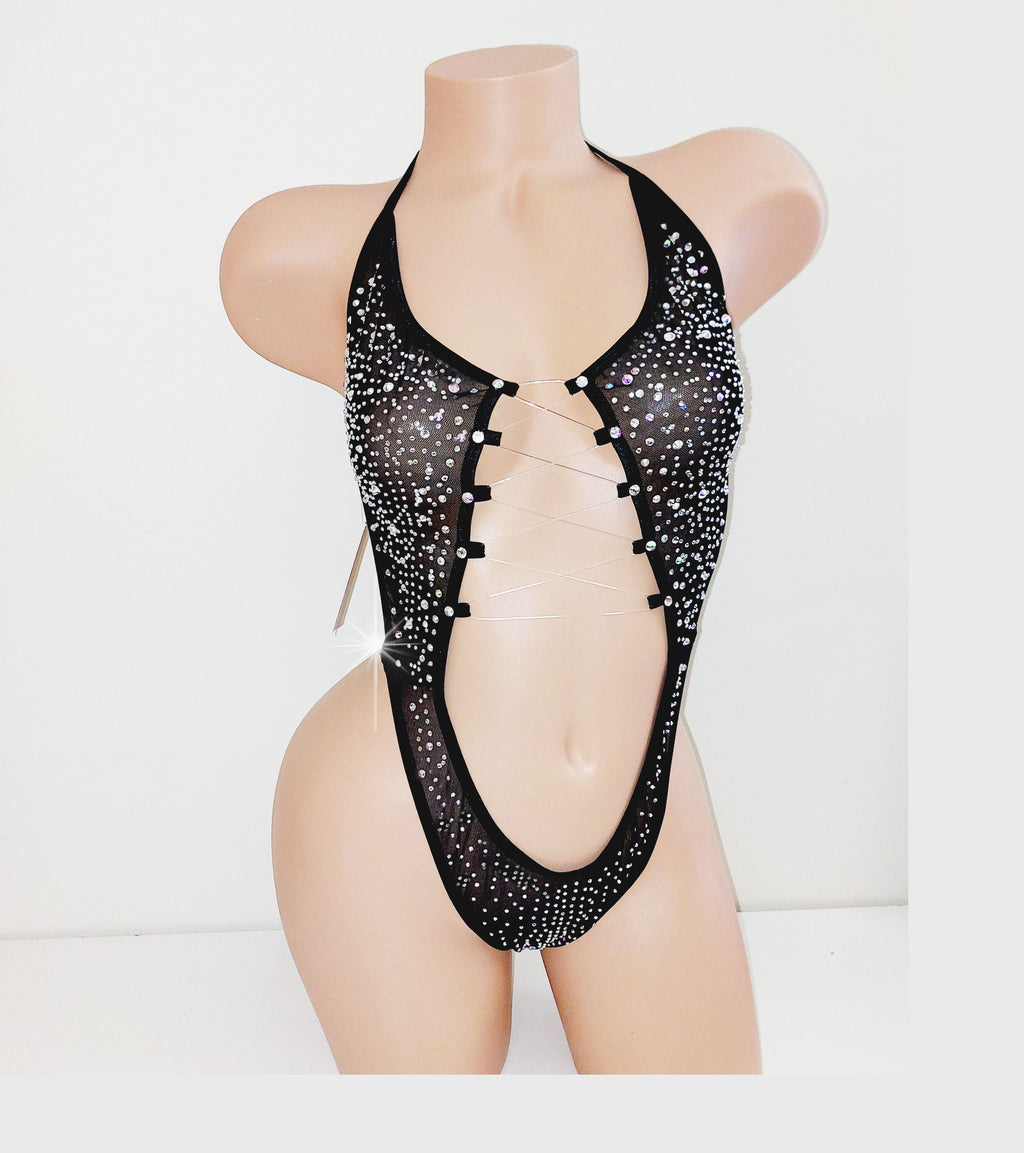 Black mesh one piece covered in rhinestones on a beige plastic mannequin torso against a plain background. 