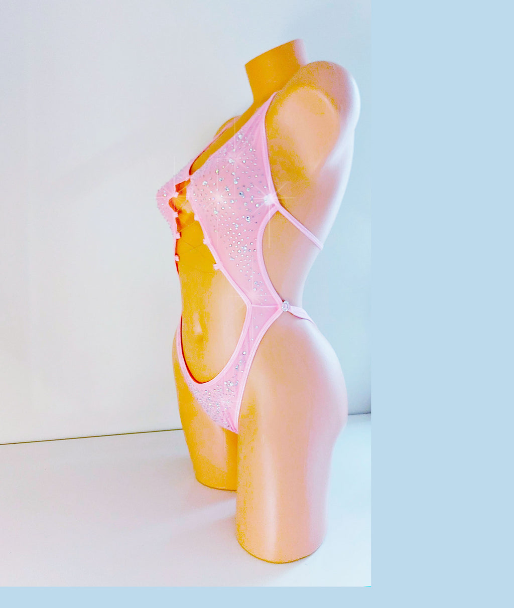 One-piece baby pink leotard bodysuit on a plastic beige mannequin torso, coveered in sparkling rhinestones all over.