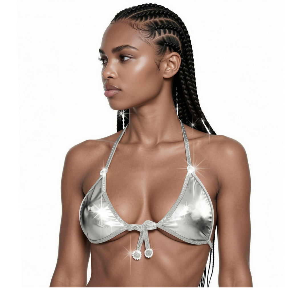 A model looking to the side and wearing a metallic silver bikini top with diamond circle accents on the adjustable straps against a white backdrop.