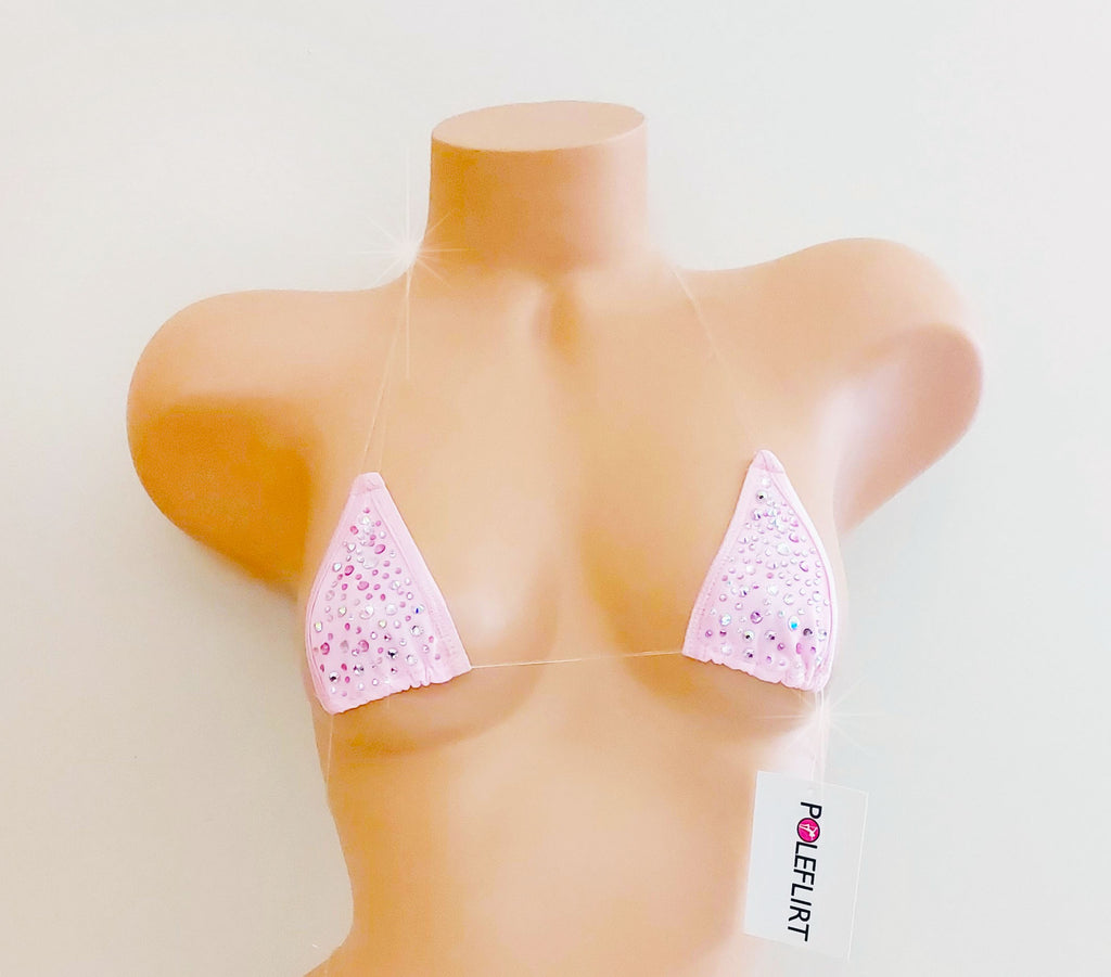 A light pink triangle bikini top with rhinestone embellishments, displayed on a tan mannequin torso against a plain off-white background. A white tag with the brand name 'POLEFLIRT' is attached near the bottom.