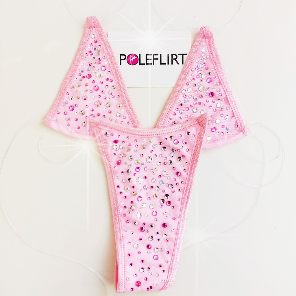 Pink rhinestone thong with a V-shape, featuring a dense pattern of pink, silver, and clear rhinestones, shown with a white brand tag labeled 'POLEFLIRT' against a white background.