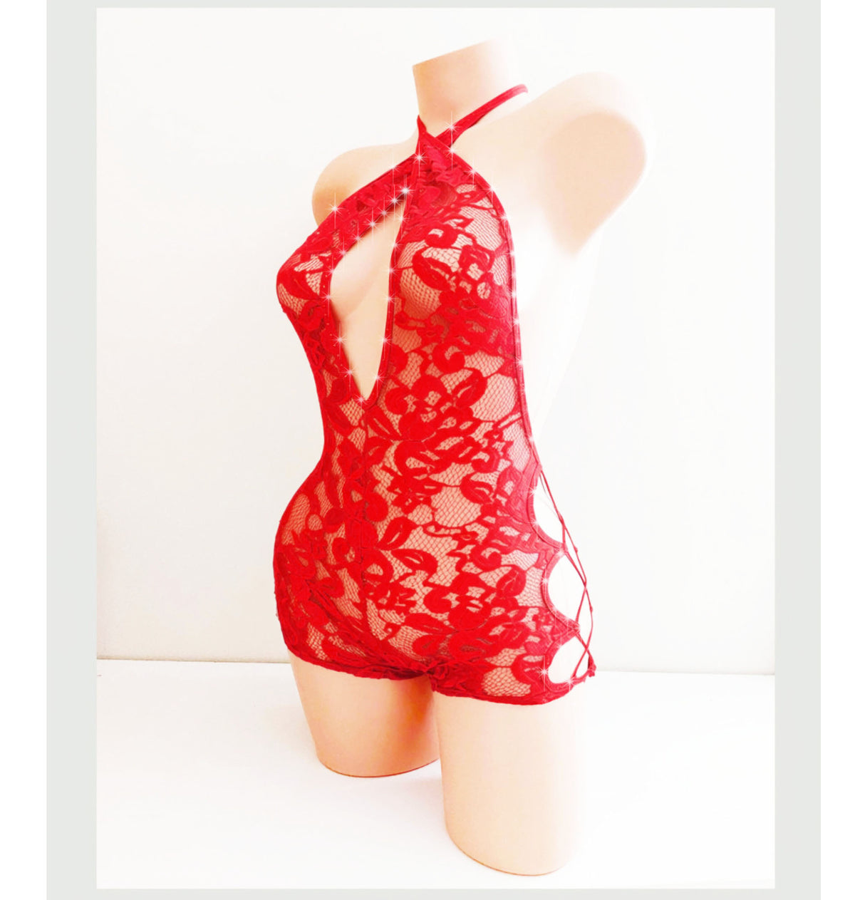 Back view of a side lace up one piece shorts romper unitard One piece shorts set with a plunging neckline on a beige mannequin, outfit is shown in Stretch lace in red and has rhinestone accents.