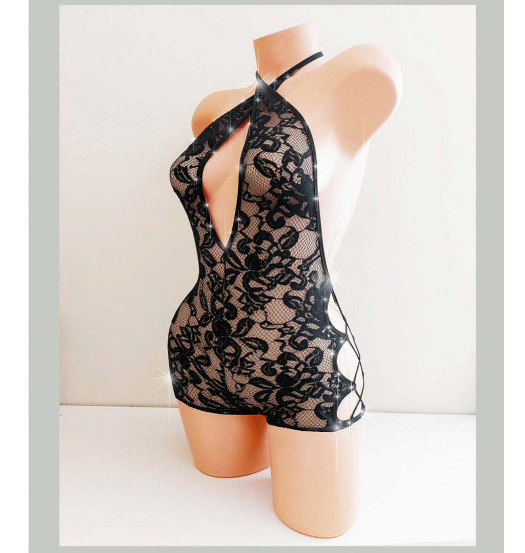  Beige mannequin torso displaying a black lace shorts one piece with side cutouts and lace ups, with rhinestone accents. 