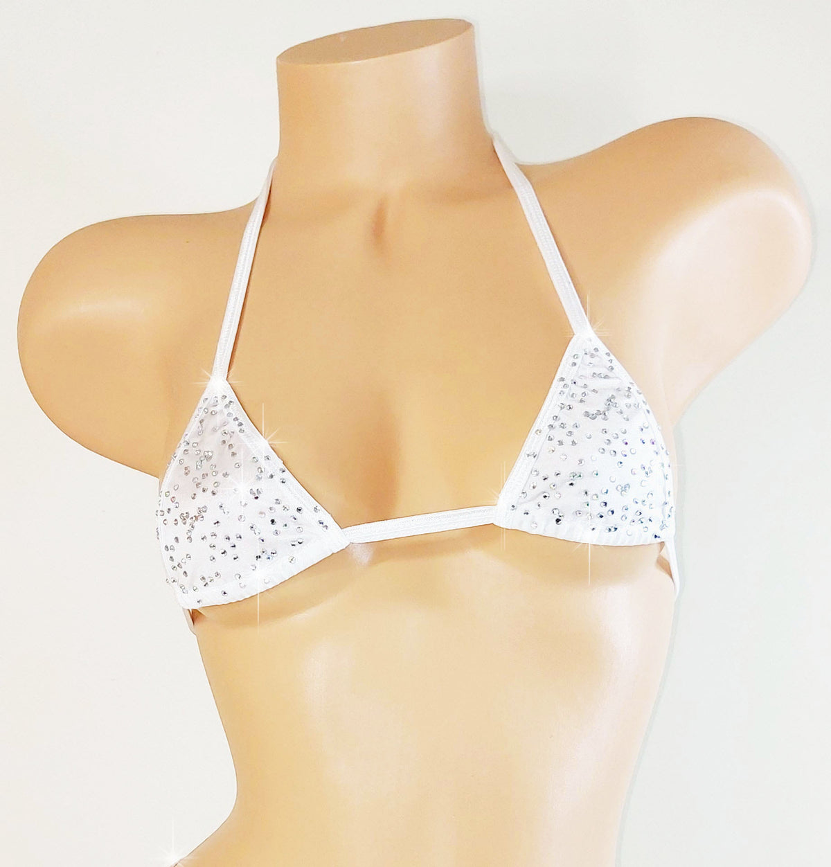 White bedazzled rhinestone bikini top with thin straps on a mannequin against a light gray background
