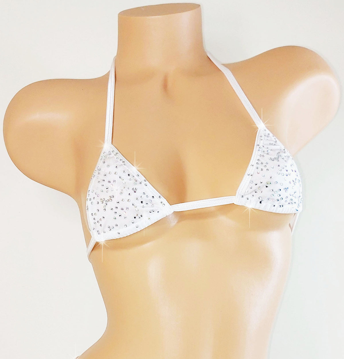 White bedazzled rhinestone bikini top with thin straps on a mannequin against a light gray background