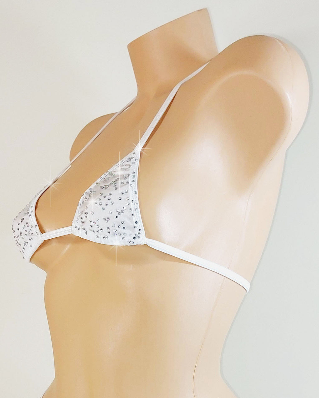 White bedazzled rhinestone bikini top with thin straps on a mannequin against a light gray background