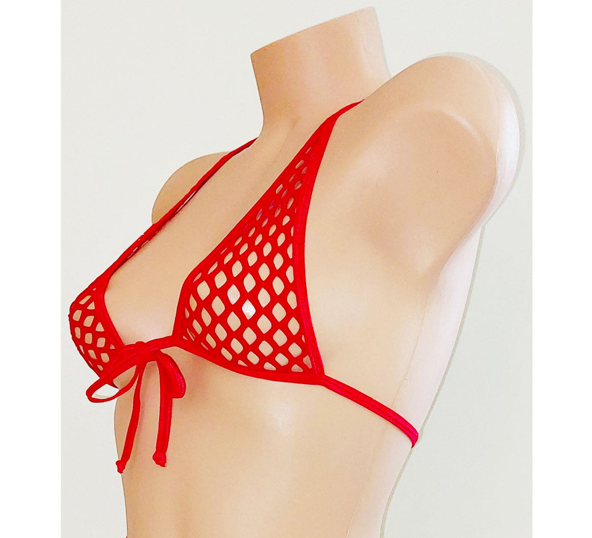 Red fishnet halter top on a beige plastic mannequin torso against a plain background.