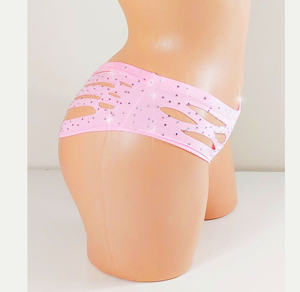 Side view of a plastic beige Mannequin torso wearing  apink pair of short shorts with cutouts and rhinestones on a white background