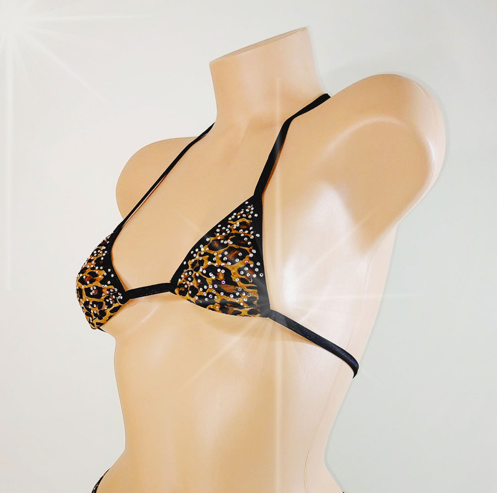 A triangle bikini top with a black leopard print pattern and rhinestone embellishments, displayed on a beige mannequin torso against a light gray background.