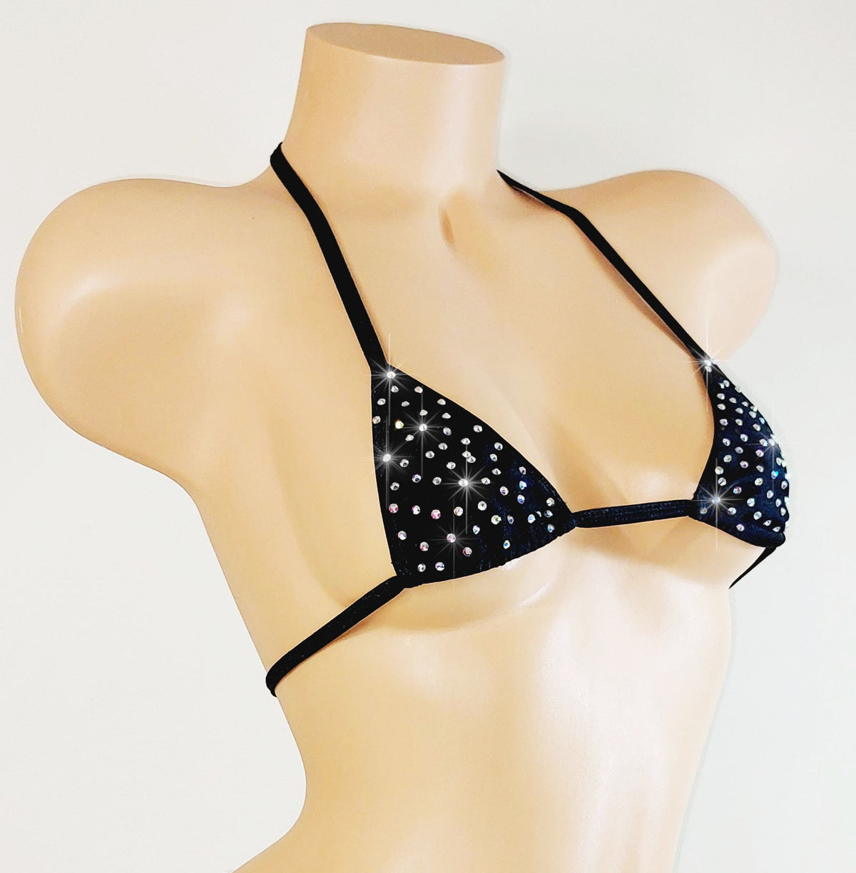 Black bikini top with sparkling stones on a mannequin against a white background