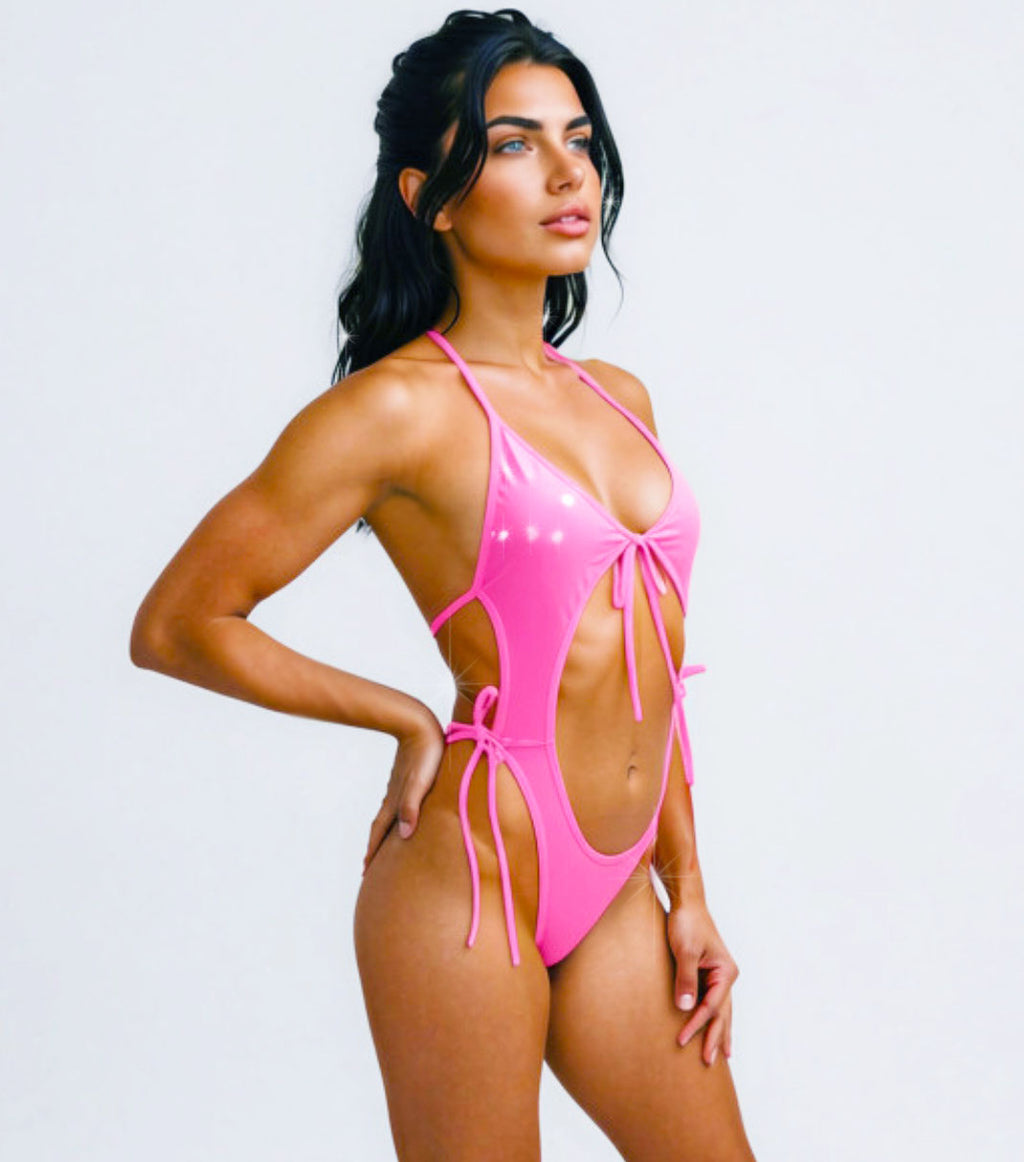 A Pink Vinyl wet look one piece backless outfit on a model against a plain background.