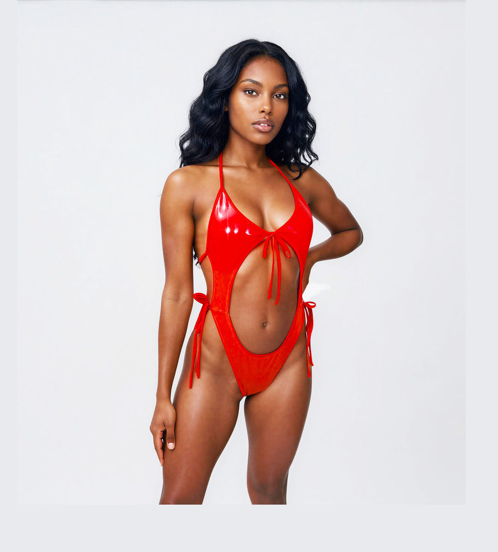 A model wearing a Red Vinyl backless one piece adjustable tie leotard bodysuit posed against a plain background.