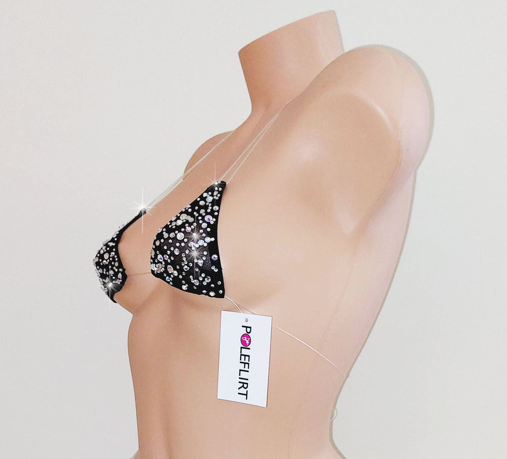 Luxury tiny micro bikini top with clear straps covered in rhinestones on a plastic beige mannequin torso on a plain background wiht a hangtag reading POLEFLIRT.