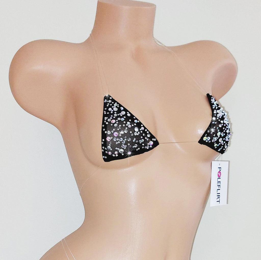 A dense pattern of sparkling rhinestones  on a tiny micro bikini top with clear straps on a plastic beige mannequin torso on a plain background with a hang tag reading POLEFLIRT.