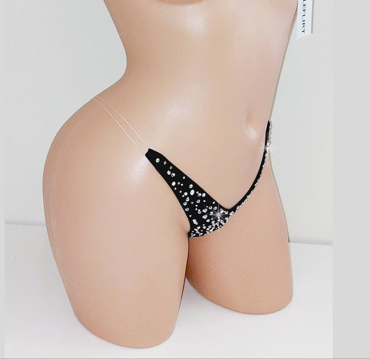 A two-piece bikini set with glittering rhinestones triangle cups and matching thong bottoms, displayed on a beige mannequin torso against a light gray background.