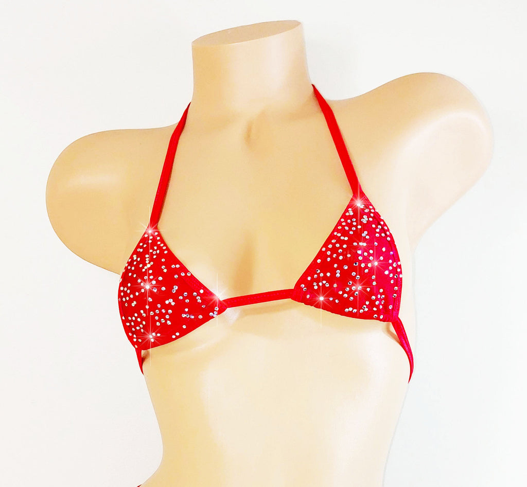 Red bikini top with star-like embellishments on a mannequin against a white background