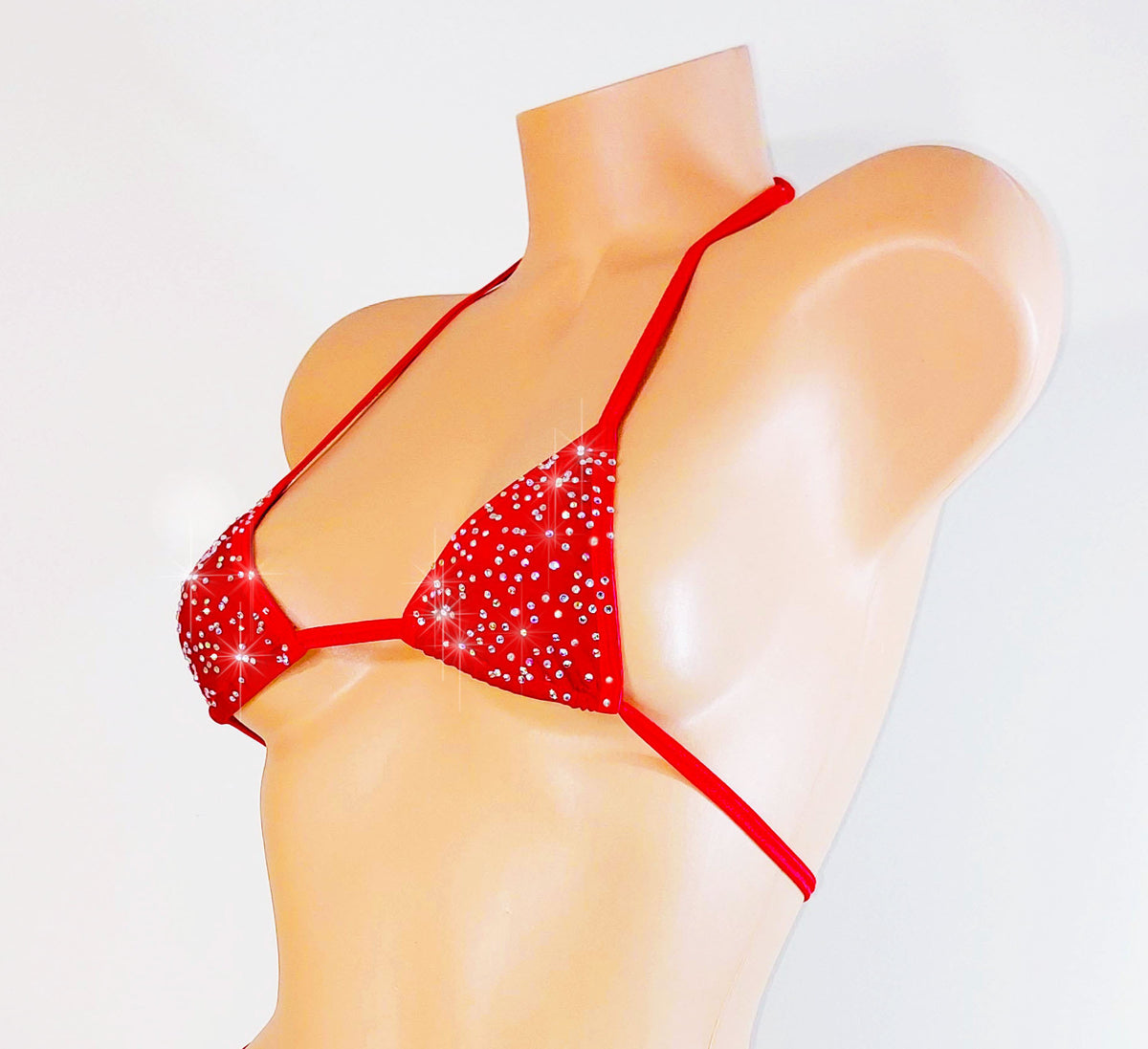 Red bikini with sparkling details on a mannequin against a white background