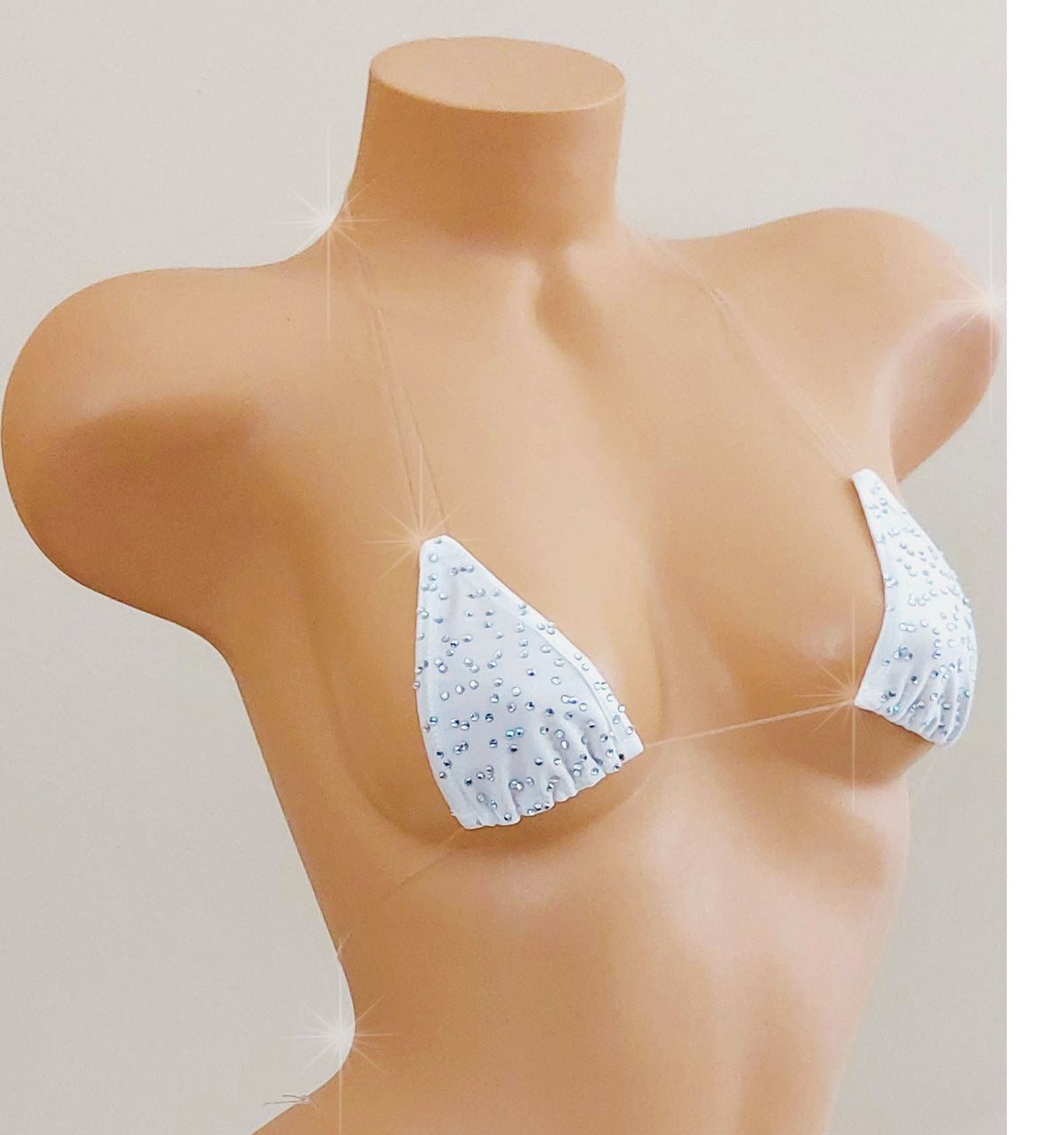 White skimpy bikini with rhinestones and invisible clear elastic straps on a mannequin torso against a blank background.