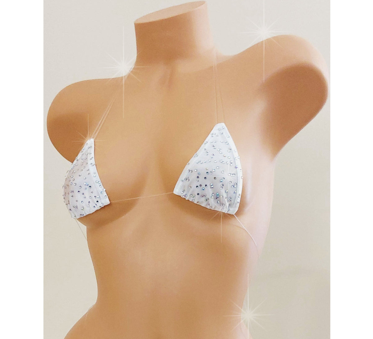 White skimpy bikini with rhinestones and invisible clear elastic straps on a mannequin torso against a blank background.