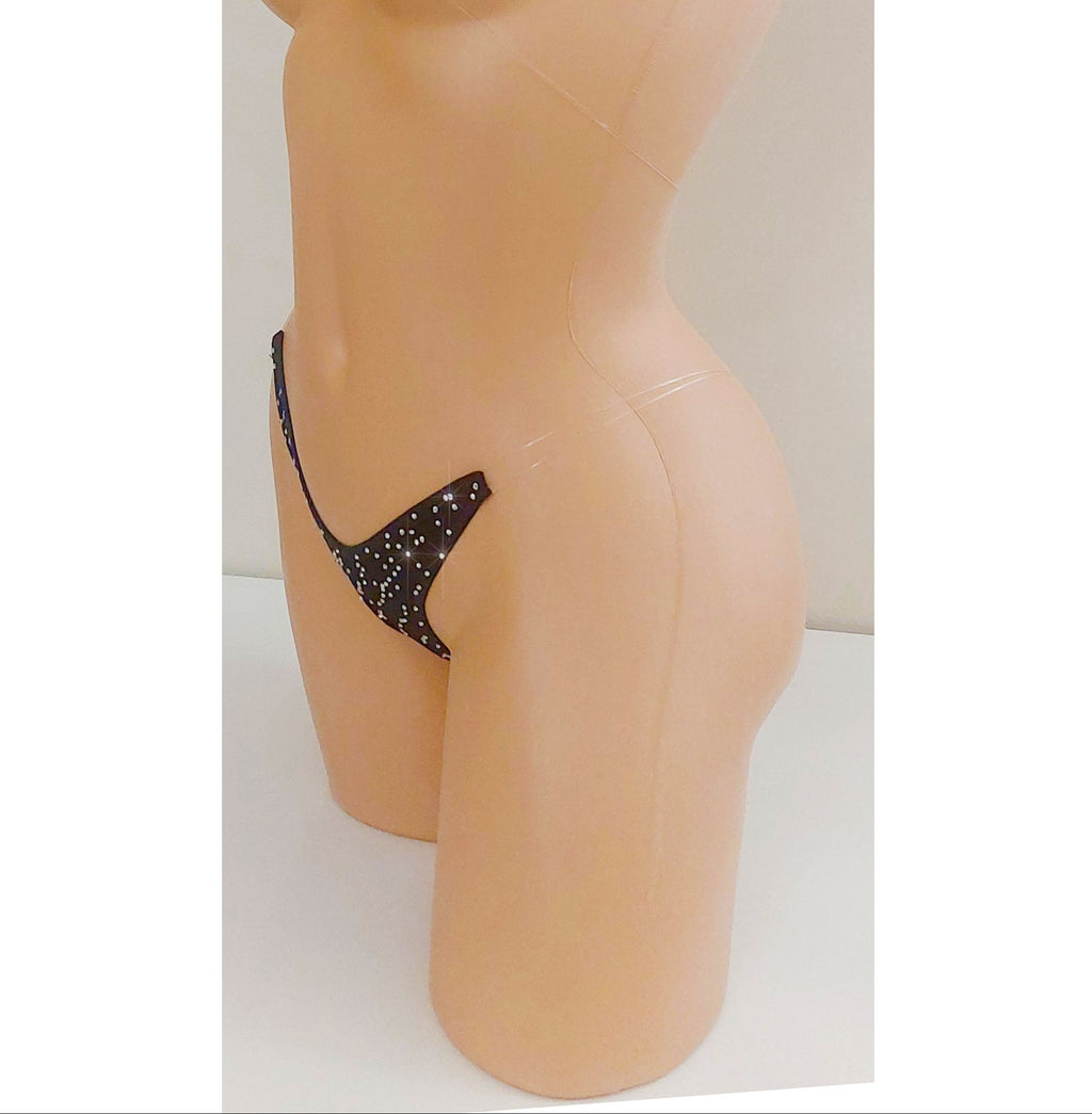 Black invisible strap micro bikini g-string thong covered in rhinestones on a torso mannequin on a white background.