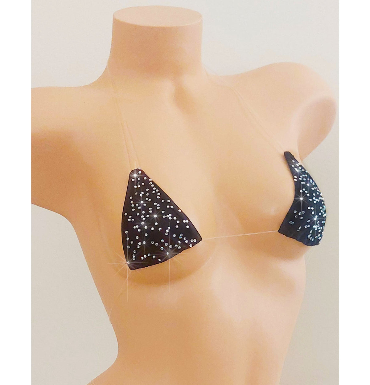 Black invisible straps micro bikini covered in rhinestones on a torso mannequin on a white background.