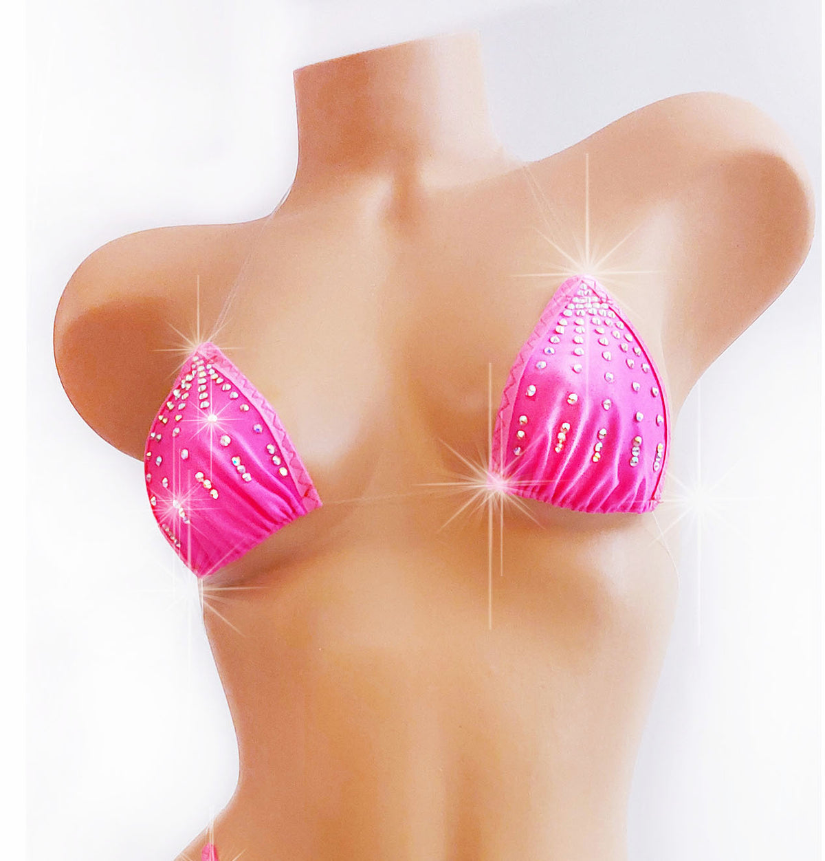 A bright pink bikini top with sparkling rhinestone embellishments displayed on a tan mannequin torso against a white background.