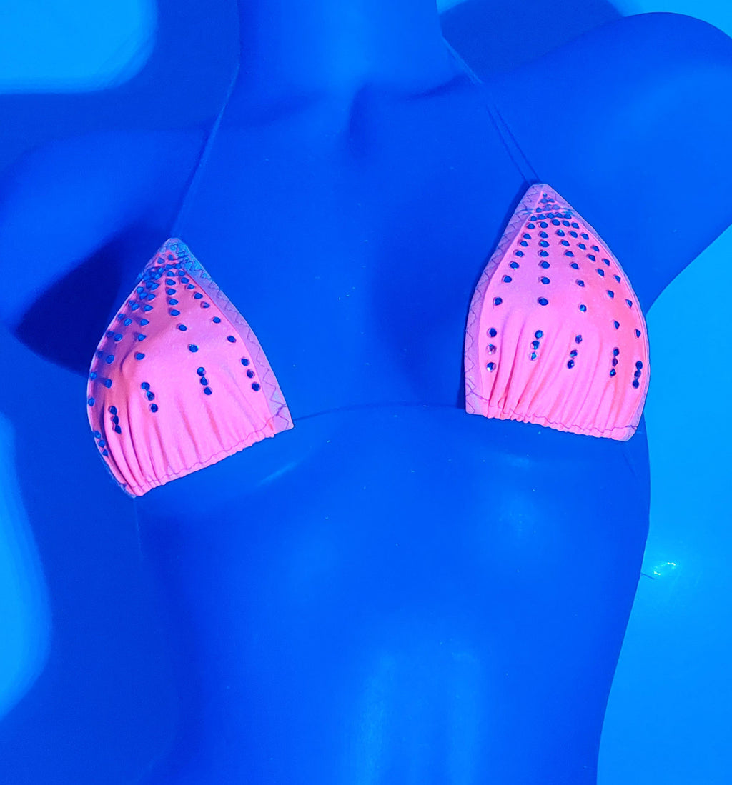Pink bikini top with rhinestone embellishments, displayed on a plastic mannequin torso under UV Black ighting.