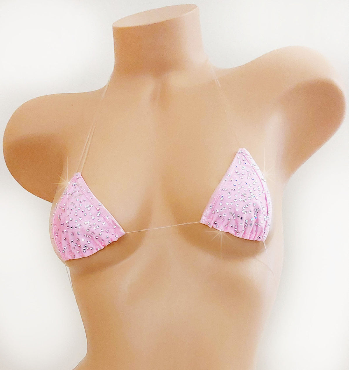 A pink triangle bikini top with rhinestone embellishments, displayed on a beige mannequin torso against a plain white background.