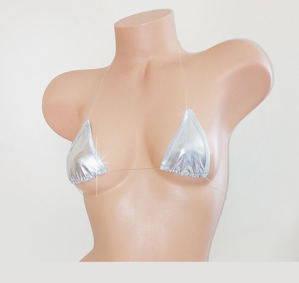 A metallic silver triangle bikini top displayed on a beige mannequin torso against a plain white background.