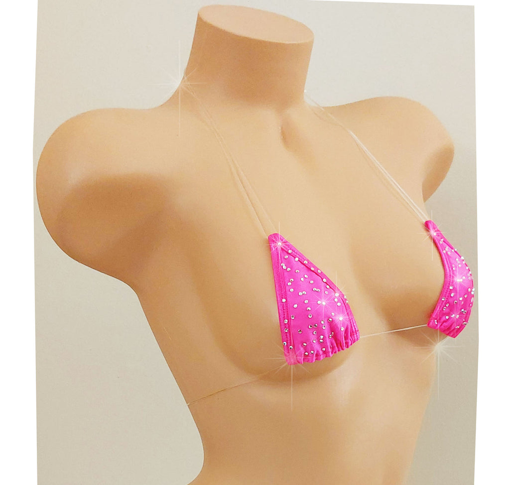 Slightly to the side view of a Hot PInk rhinestone bikini top with clear elastic cord straps that appear invisible on a torso mannequin on a white background.