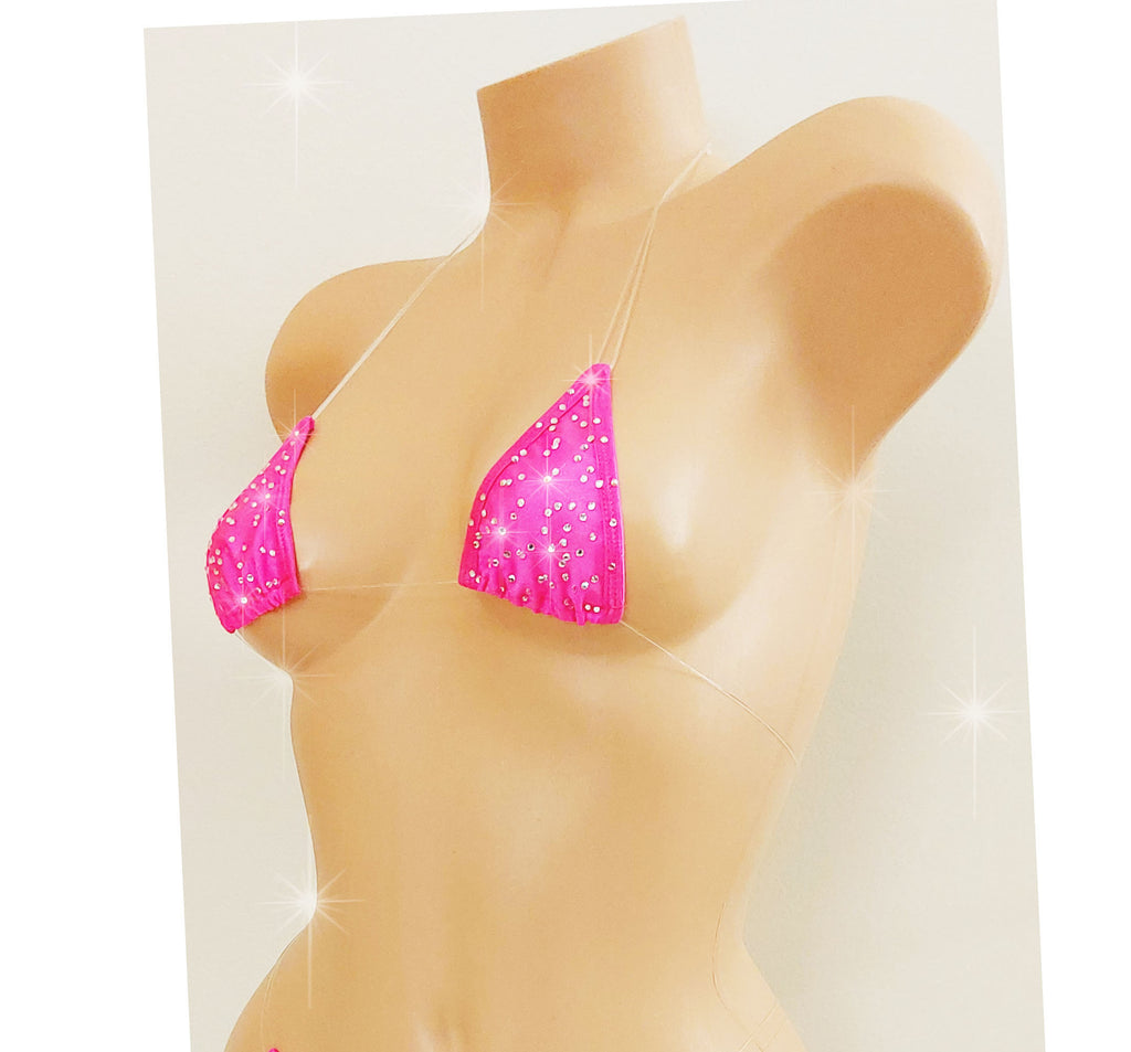 SIde view of a Hot PInk rhinestone bikini top with clear elastic cord straps that appear invisible on a torso mannequin on a white background.