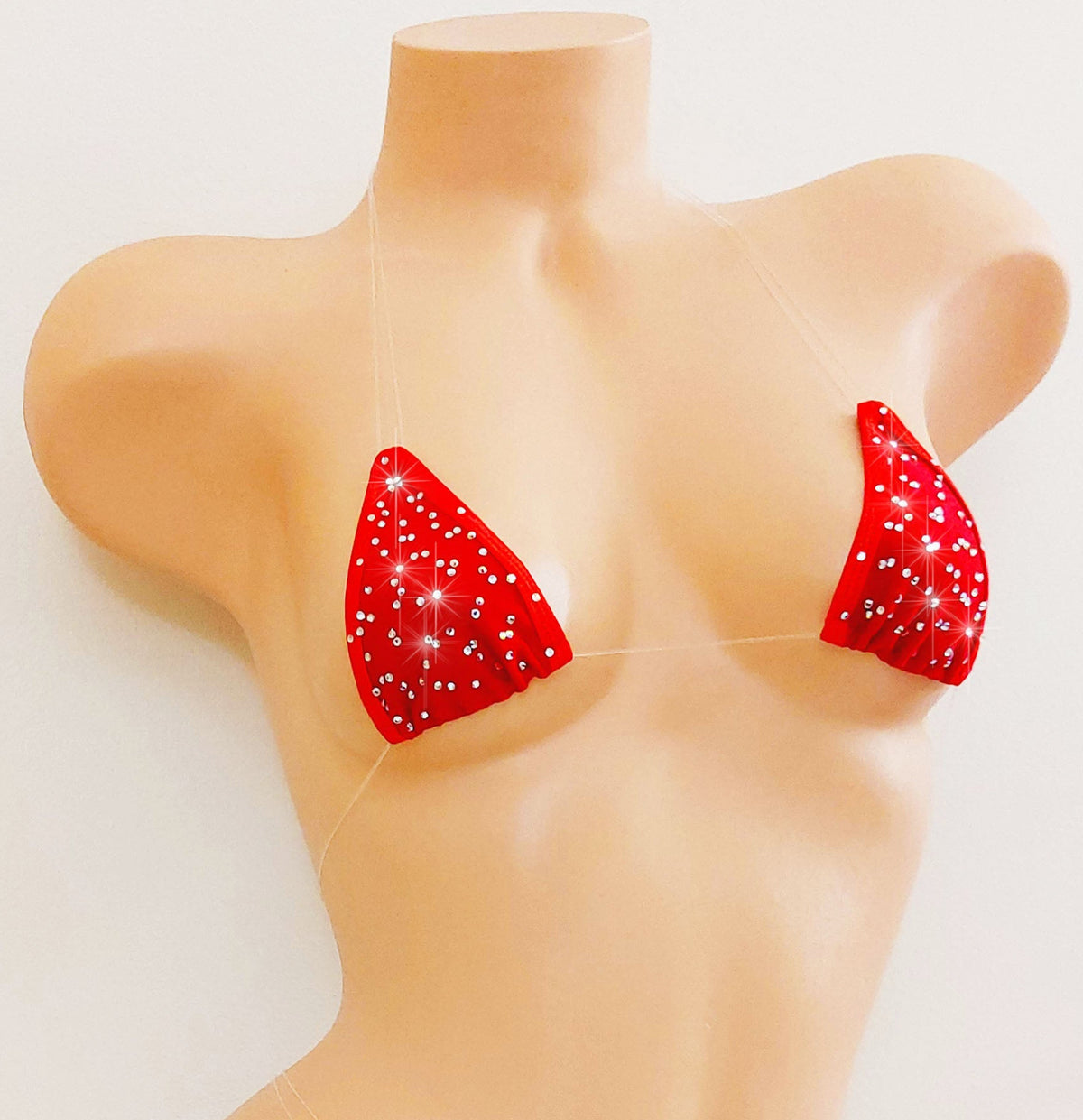 Red bikini top scattered with rhinestones with clear invisible straps on a mannequin.