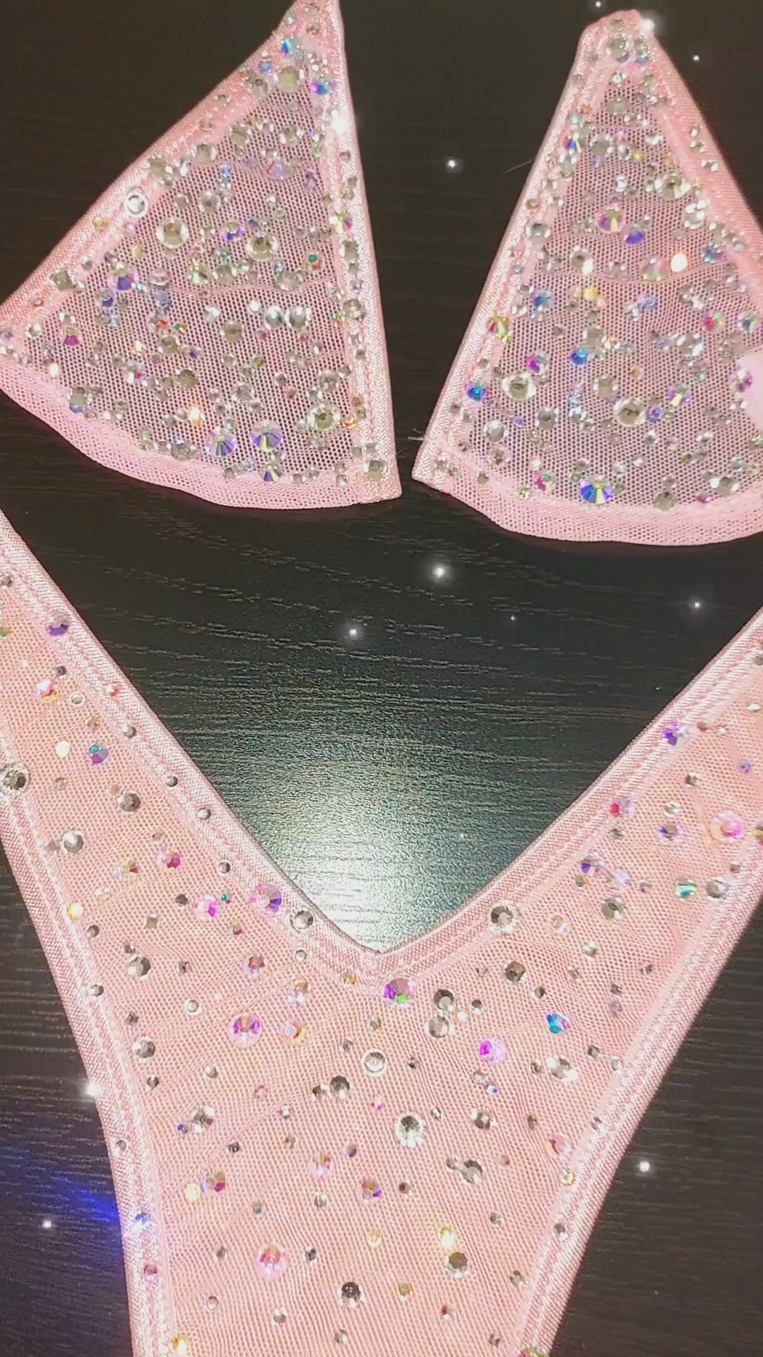 Video of a beige mannequin displaying several colors of a minimal coverage bedazzled clear elastic string bikini.